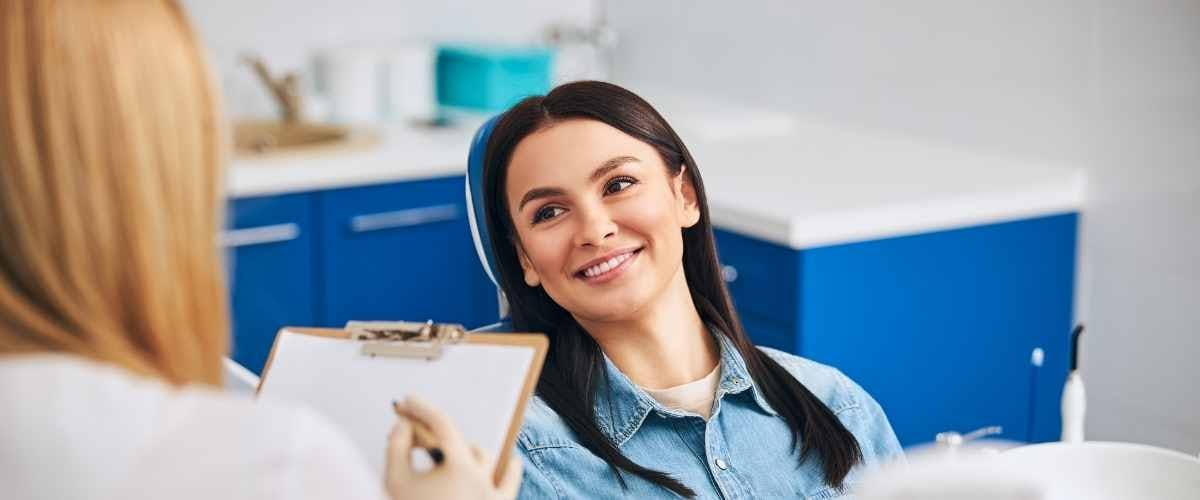 Woman smiling during a cosmetic dental consultation with a dentist discussing treatment options.